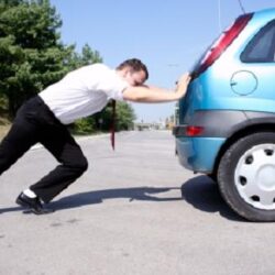 guy pushing car